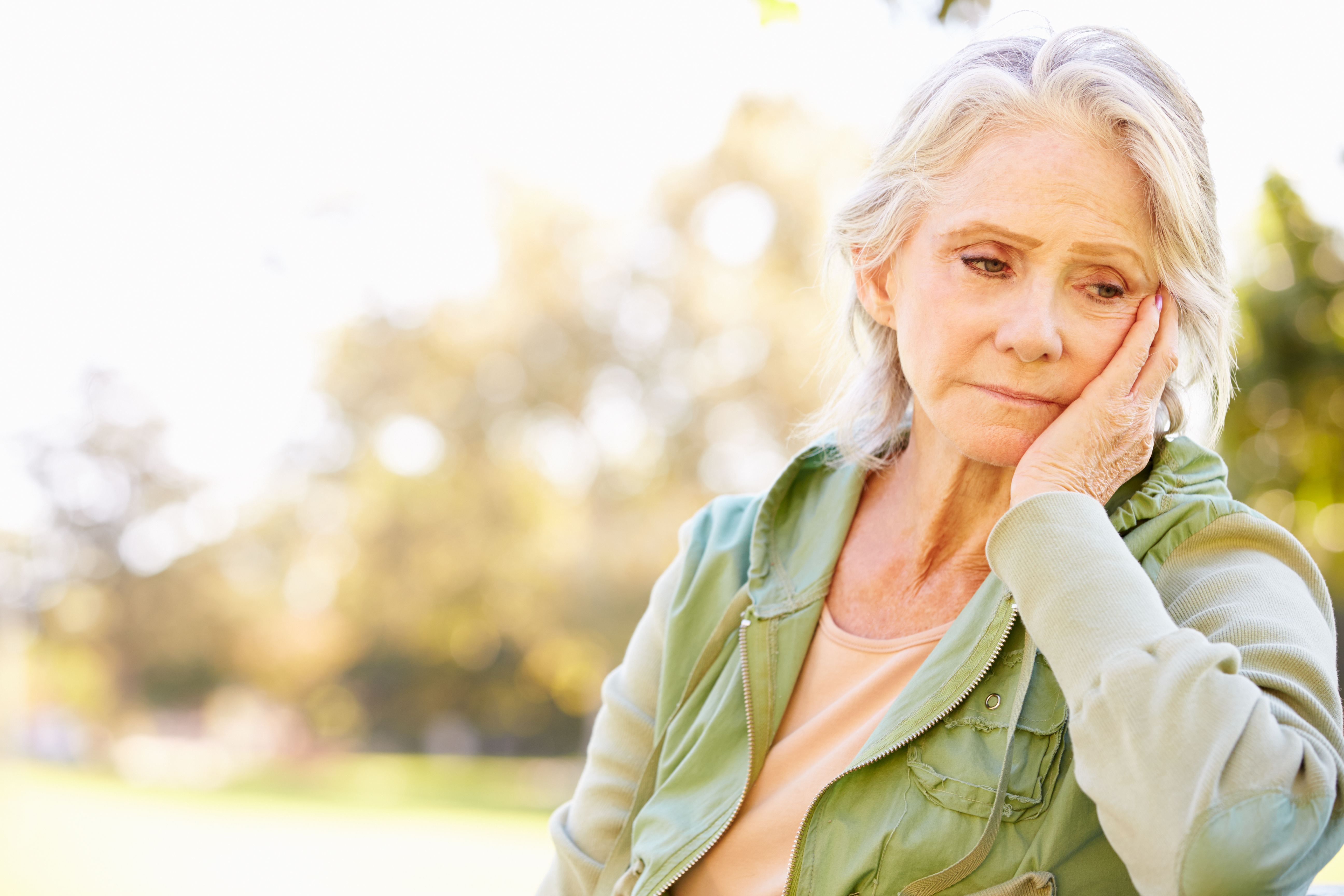 Depressed Senior Woman Sitting Outside